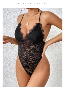 Macro detail of black eyelash lace bodysuit featuring sheer floral patterns and deep V-neck