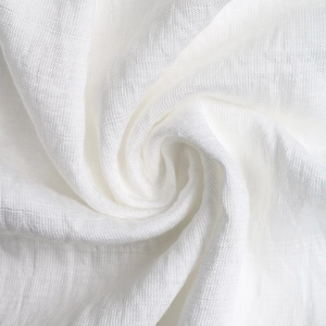 Macro d'une jupe en dentelle blanche montrant la texture fine et le tissage aspect lin