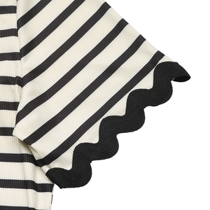 Close-up of black and white striped knit top with black scalloped lace hem details