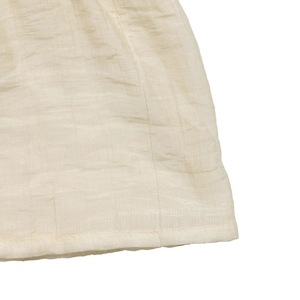 Détail du tissu en double gaze crème avec texture froissée légère et coutures fines