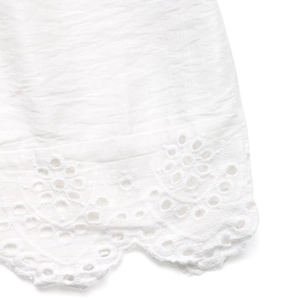 Détail de la broderie anglaise blanche et de l'ourlet festonné sur une jupe longue