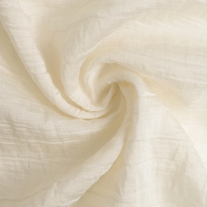 Gros plan sur un tissu mousseline blanc avec texture plissée délicate et drapé ondulé