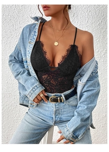 Detail of black lace bodysuit featuring a deep V-neckline paired with a denim jacket