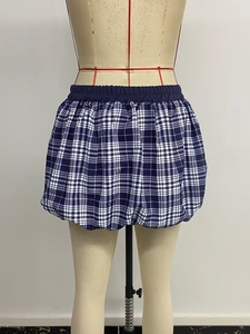 Detailed view of dark blue plaid bubble skirt showing elastic waist and ruffled hem