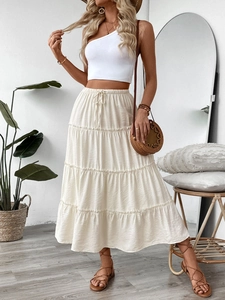 Detail of bohemian tiered white maxi skirt with elastic drawstring waist and pleated texture