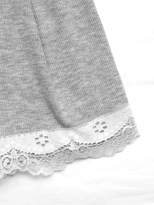 Gros plan sur le tissu gris côtelé avec une bordure en dentelle blanche et motifs floraux