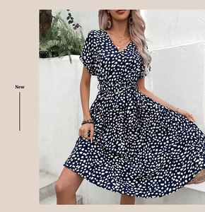 Détail de la robe bleu marine à col en V avec pois blancs et ceinture à la taille