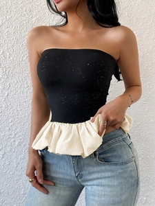 Women's chic black sequin tube top with cream ruffled peplum hem paired with blue jeans