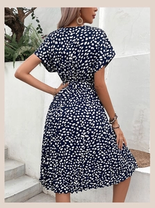 Détail d'une robe bleu marine à imprimé floral avec manches courtes et ceinture assortie