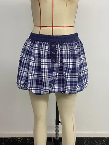 Detail view of the elastic waistband and decorative buttons on the blue plaid bubble skirt