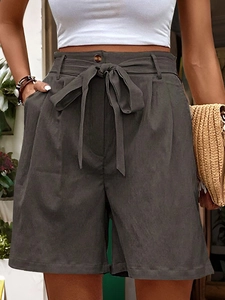Detail of high waisted dark grey casual shorts featuring tie-up belt and side pockets