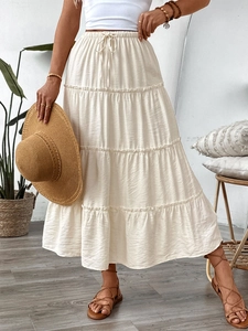 Detailed view of cream-colored tiered maxi skirt with elastic drawstring waist design