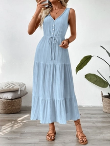 Détail d'une robe longue bleu clair à col en V avec tissu texturé et ourlet à volants