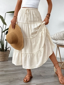 Detailed view of white boho tiered maxi skirt with elastic drawstring waist and pleated texture
