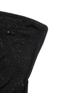 Close-up of black shimmering fabric with star-like glitter and flatlock stitching details