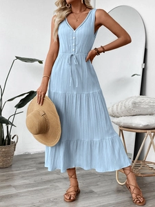 Détail de la robe bleu clair à col en V avec tissu texturé et jupe à plusieurs niveaux