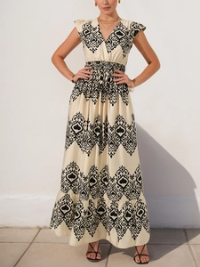 Detail of V-neck bohemian print dress with high waist design and tiered maxi skirt