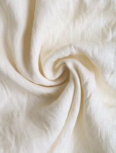 Macro detail of breathable cream textile fabric with soft texture and vertical drape