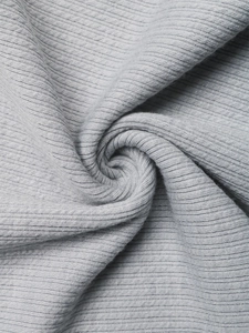 Macro shot of light grey ribbed knit fabric showing the soft elastic texture of the set