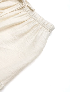 Detail view of elastic waist with drawstring on cream-white A-line skirt