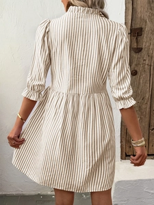 Close-up of a striped dress with a ruffled collar and puffed sleeves from behind