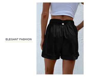 Detail view of high-waist black shorts with textured fabric and metallic back button