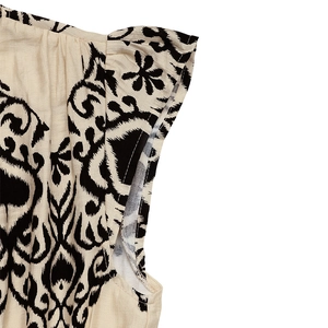 Detailed macro view of bohemian printed flutter sleeves on cream ethnic dress