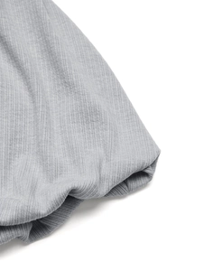 Detail of light gray ribbed knit fabric showing vertical texture and soft material