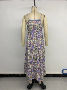 Detail eines gestuften Maxikleides mit schmalen Trägern und lila Blumenmuster im Sommer