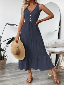 Détail de la robe longue à volants avec col en V en tissu texturé et taille à cordon