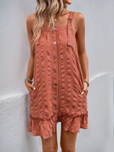 Detail of brick red textured strap dress showing button front and ruffle hem design