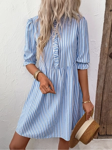 Détail d'une robe à rayures verticales bleues et blanches avec volants et boutonnage