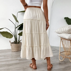 Elegant white tiered A-line maxi skirt with elastic high waist and pleated texture