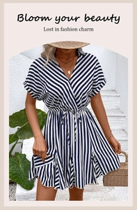 Close-up of blue and white striped summer dress featuring a waist tie and V-neckline detail