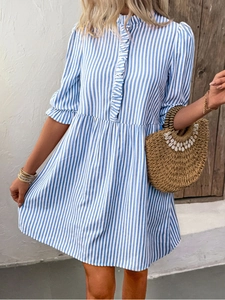 Détail d'une robe d'été à rayures bleues et blanches avec volants et motif vertical