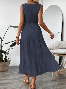 Détail d'une robe longue bleu marine à volants avec tissu texturé et dos sans manches