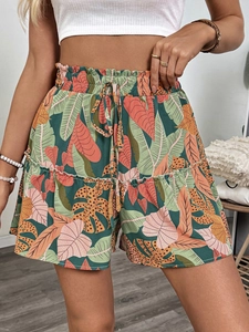 Detail of high waist tropical print shorts with elastic waistband and ruffle hem