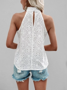 Detail of white halter neck top with schiffli floral embroidery and back button closure