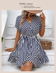 Vertical blue and white striped mini dress with waist tie on a seated fashion model