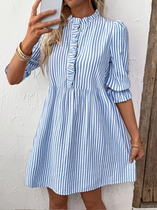 Détail de la robe chemise à rayures bleues et blanches avec volants et taille haute