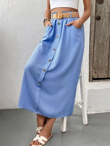 Detail of light blue linen skirt with wooden buttons and woven belt with a round buckle