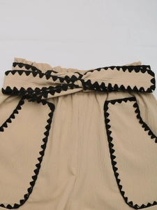 Detail view of khaki casual shorts featuring elastic high waist and black lace trim