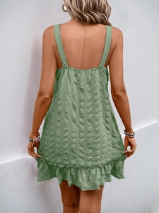 Detailed back view of green textured strap dress with ruffle hem and backless design