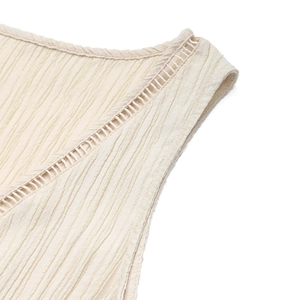 Détail du col en V avec dentelle échelle et tissu à texture gaufrée en beige crème