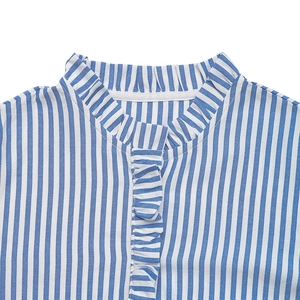 Détail d'une chemise à rayures verticales bleues et blanches avec col à volants et plis