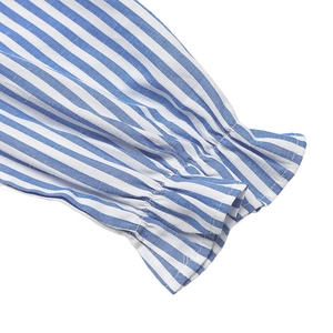 Détail de la robe chemise à rayures verticales bleues et blanches avec poignets à volants