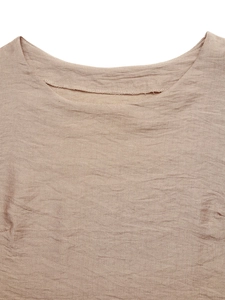 Detailed view of sleeveless top neckline showing crinkle texture and clean edge stitching