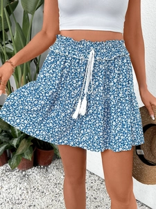 Detail of floral mini skirt with elastic high waist and white tassel drawstrings