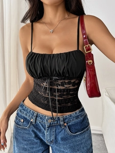 Detail of slim fit black lace camisole with thin straps and bow accent on front