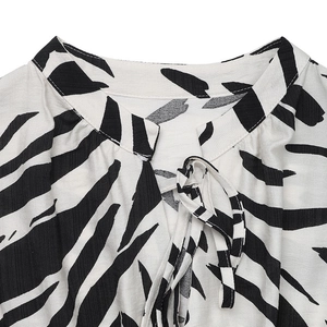 Detail of V-neckline with tie closure on a zebra print sleeveless summer dress